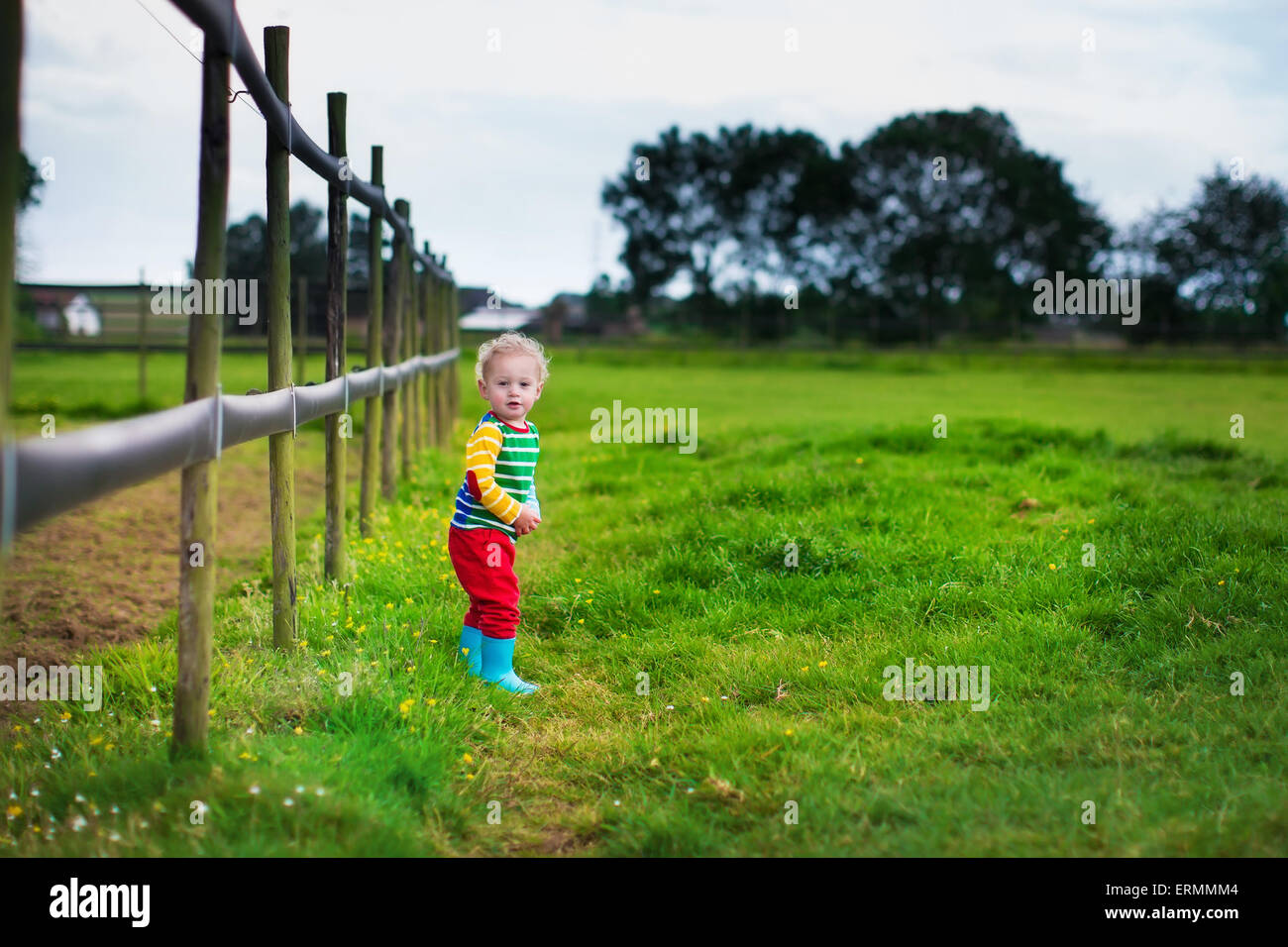 Drôle de petit garçon sur une ferme. Les enfants jouent à l'extérieur. Aider les enfants d'âge préscolaire dans le jardin. Les enfants au jardinage. Banque D'Images