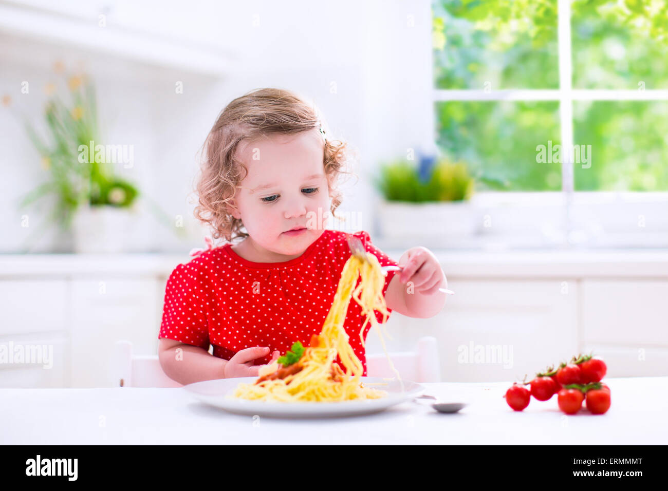 Les enfants mangent des pâtes. Dîner sain pour les enfants. Tout-petit enfant mange du spaghetti Bolognese dans une cuisine blanche à la maison. Enfant d'âge préscolaire Banque D'Images