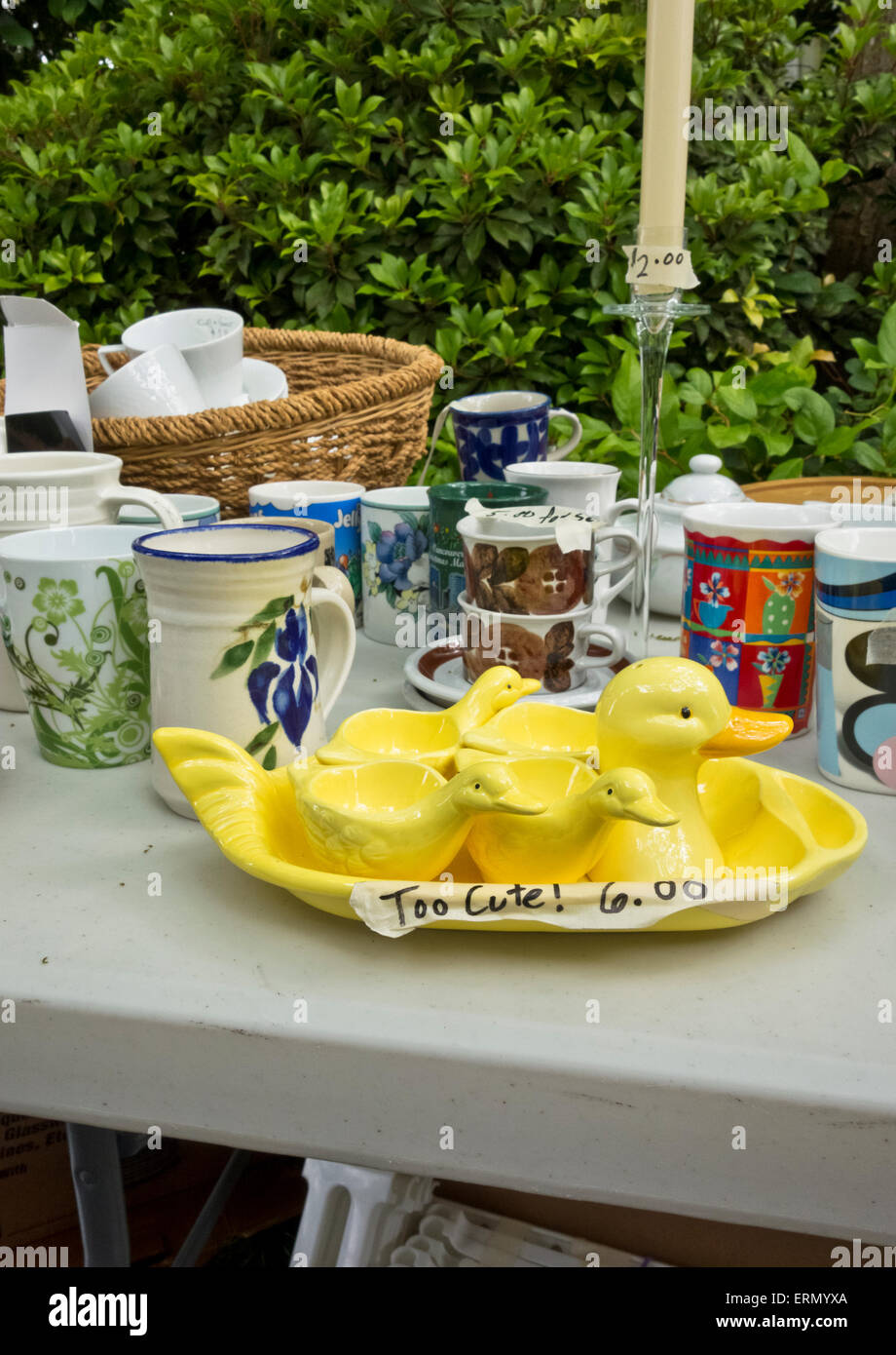 Collection d'articles de cuisine en vente sur une table à la vente de garage. Cute yellow duck egg cups set. Deuxième part d'articles de ménage. Banque D'Images