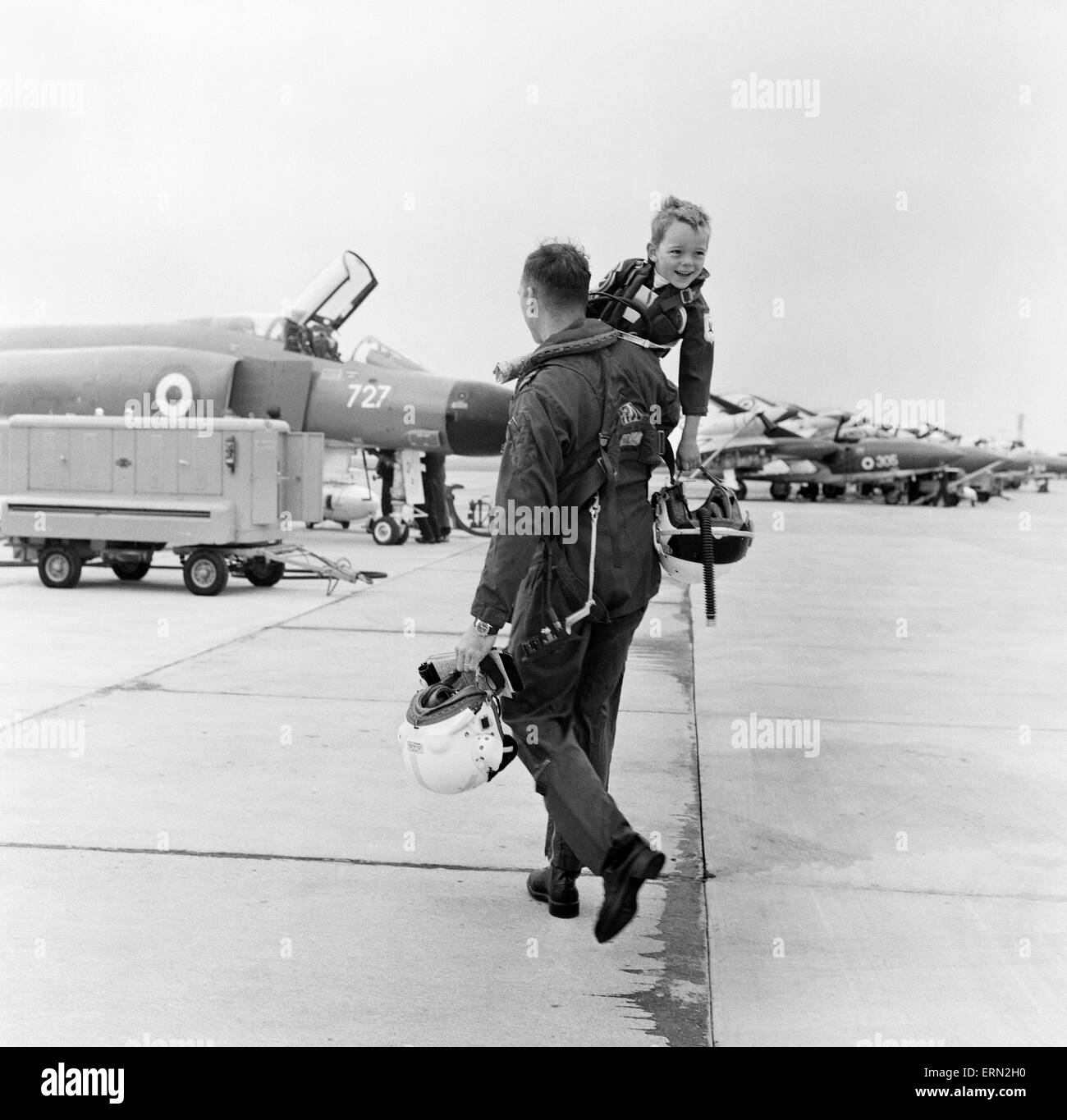 Pilote fantôme Lieutenant Commander Peter Marshall de la Fleet Air Arm, avec son fils de quatre ans Richard vêtu de l'uniforme de pilote correspondant à la Royal Naval Air Station à Yeovilton, Somerset. Le 700 Escadron Fantôme doit figurer au Farnborough Air Show le mois prochain, mais à l'heure Richard est d'être mascotte de la Journée de l'air afficher complet avec sa tenue. 13 août 1968. Banque D'Images