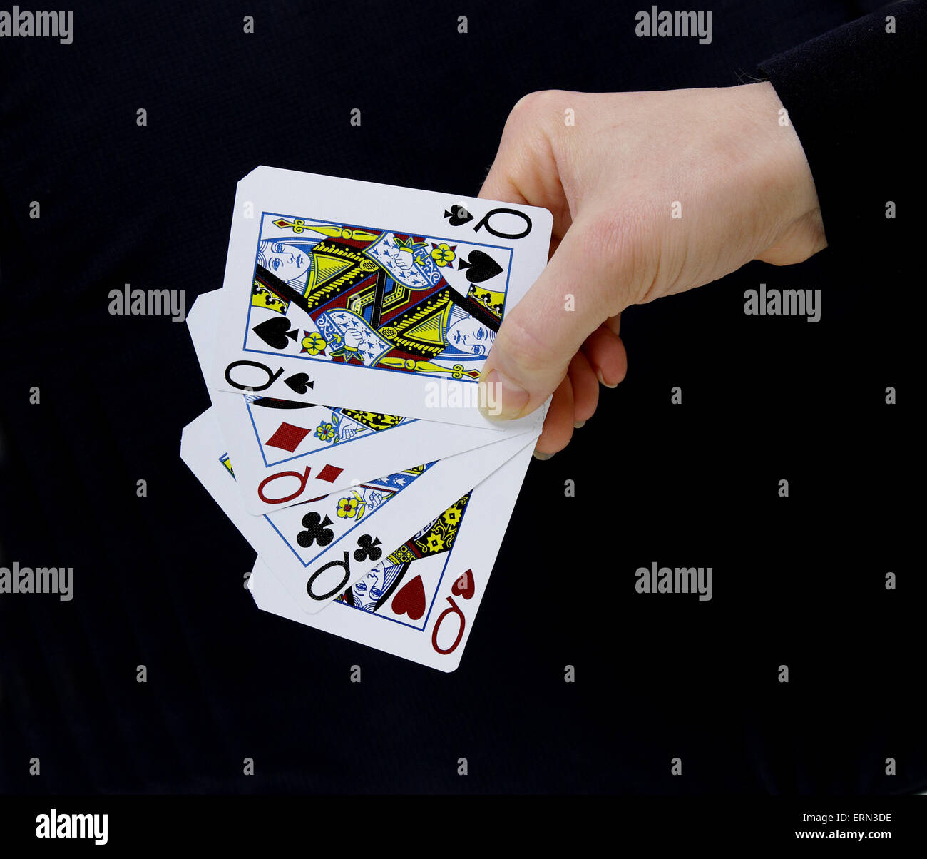 Croupier joueur tenant en main les reines carte de pique un carré sur fond noir Banque D'Images