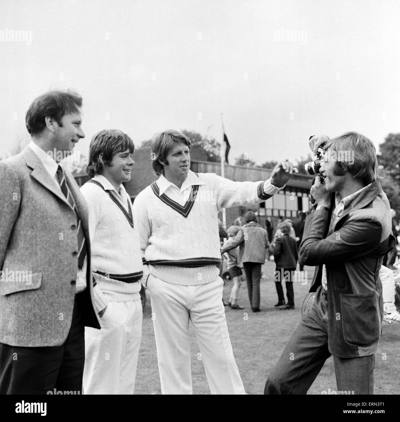 L'équipe d'essai australien de tournée en Angleterre , visiter Southgate cricket club avant les matches de cendres. L'un des membres du Southgate Ross Collins cassé la chance d'obtenir une photo de fast bowler Jeffrey Thomson (à droite) et Jim Higgs (centre) avec Southgate le capitaine Jim Conroy (à gauche). 4 juin 1975. Banque D'Images