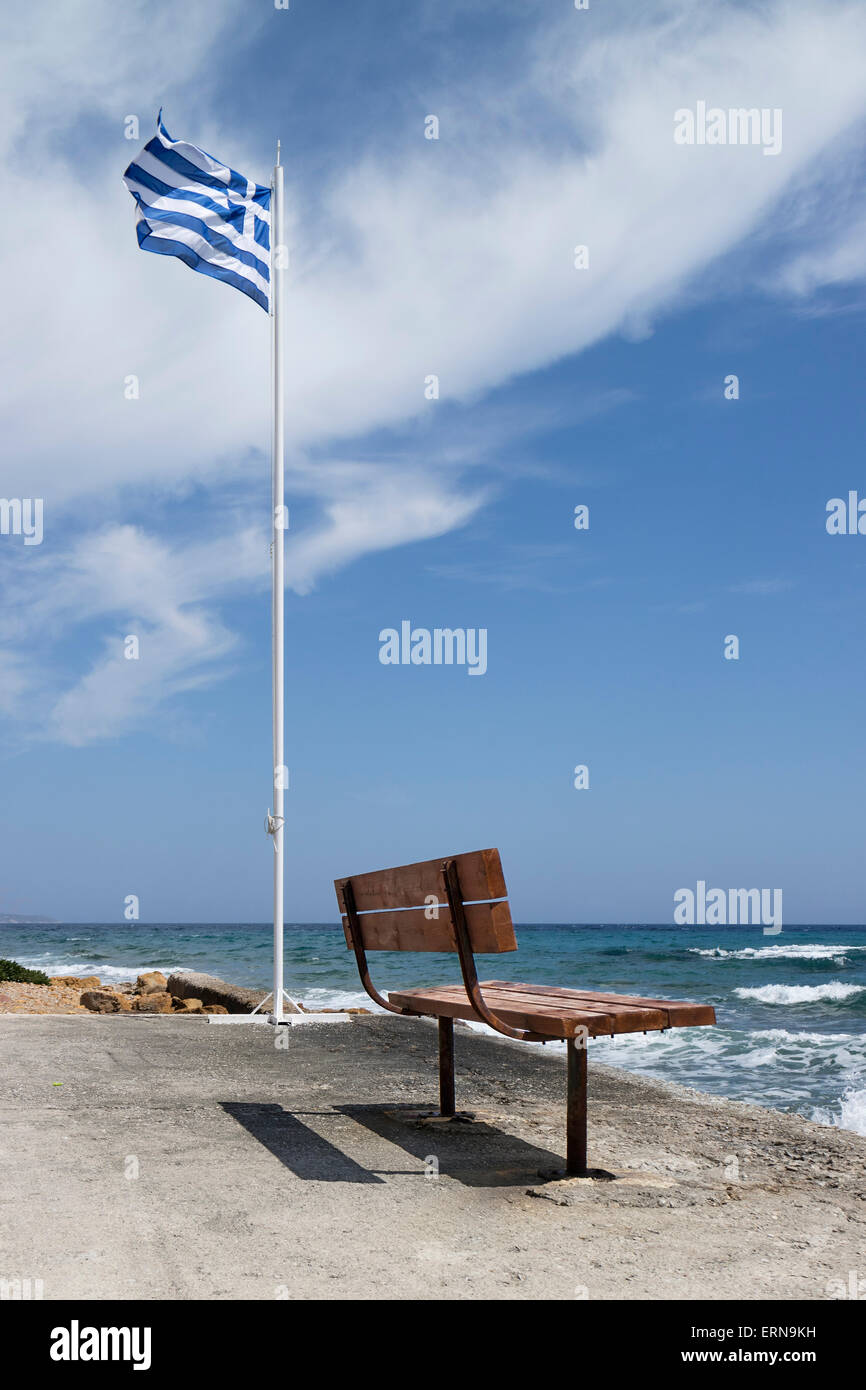 Bannière grecque et banc vide sur la plage de Mega Limnionas, sur l'île de Chios, Grèce Banque D'Images