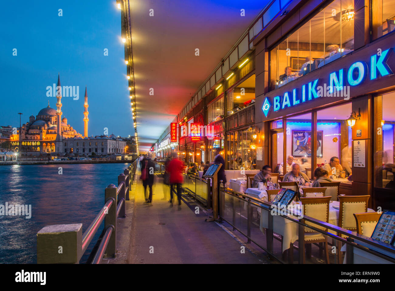 Restaurants en plein air sous le pont de Galata avec Yeni Cami ou nouvelle mosquée dans l'arrière-plan au crépuscule, Istanbul, Turquie Banque D'Images