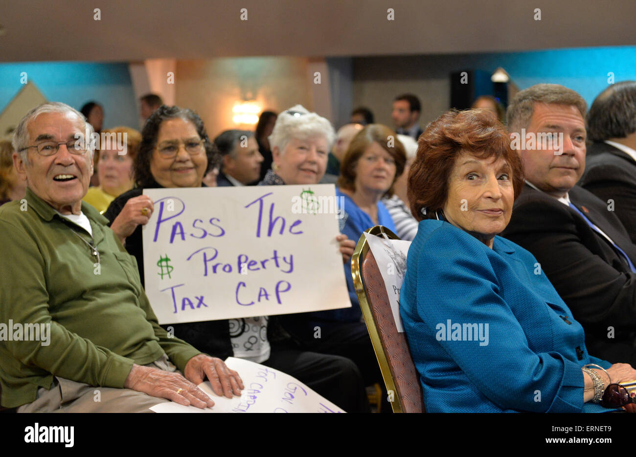 Ingelmunster, New York, USA. 3e juin 2015. À l'extrême droite en bleu, Président de l'Assemblée législative du comté de Nassau NORMA GONSALVES (Rempl. - East Prairie, LD 13), et les personnes âgées à passer le cap de l'impôt foncier Les affiches sont parmi les participants Conférence de presse Soutien à l'extension de l'impôt foncier NY Pac. Lors de l'événement bi-partisan à la salle des Chevaliers de Colomb, plus d'une centaine de résidents du secteur et les fonctionnaires, et le gouverneur, a encouragé l'extension de la taxe foncière le bouchon avant la session législative de l'état se termine le 17 juin. Credit : Ann E Parry/Alamy Live News Banque D'Images