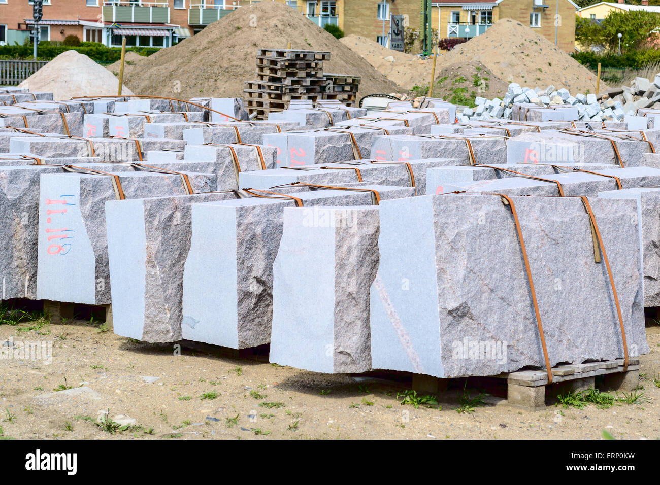 De grandes dalles de granit garantis par des courroies sur palettes. Chaque pierre est numéroté pour faciliter le montage à la livraison. Tas de terre en retour Banque D'Images