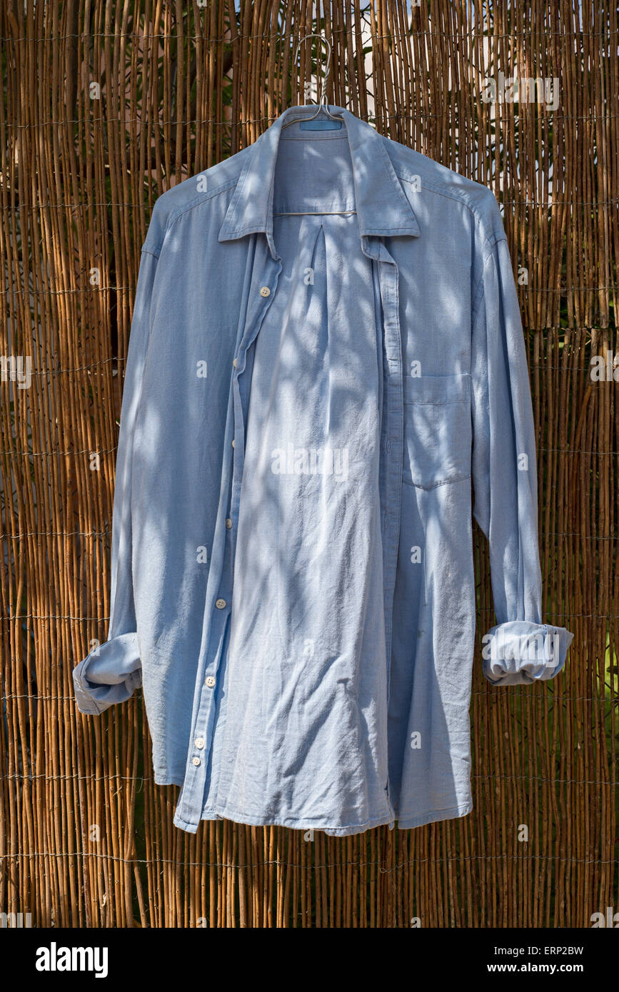 Chemise bleu accroché sur le mur en osier Banque D'Images