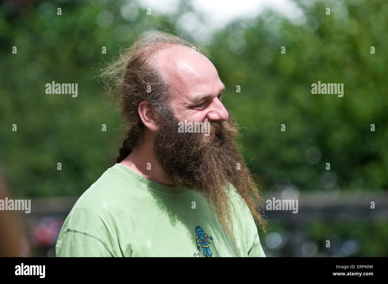 Un homme avec une tête chauve mais une très longue barbe et une queue de  cheval a l'air très content dans la campagne anglaise Photo Stock - Alamy