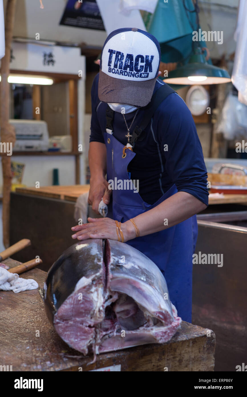 Le thon frais coupé principal par des manutentionnaires de thon japonais Tsukiji au marché du poisson et des fruits de mer, juste après la vente aux enchères de thon. Banque D'Images