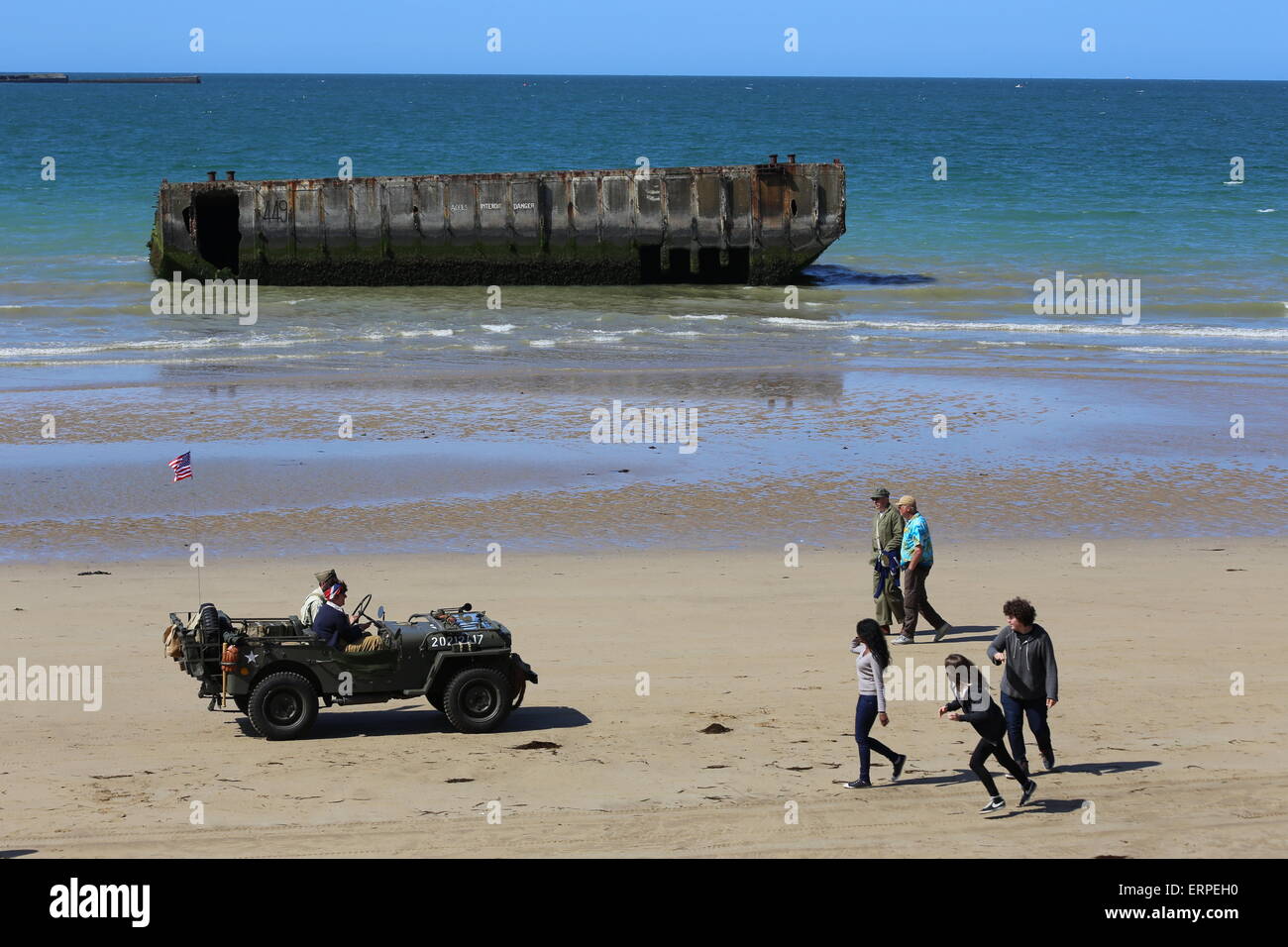 D-Day 71ème anniversaire de la Normandie, France. Services et des parades musicales sont organisées pour marquer l'Arromanche en 71e anniversaire du débarquement. Les anciens combattants et le public à profiter de la journée, le site de l'Arromanche Mulberry Harbour et les sites de débarquement. Re-enactment groupes dans unifroms période affiche vintage WW2 des véhicules pour une toile de fond de l'ère des années 1940, la musique. Banque D'Images