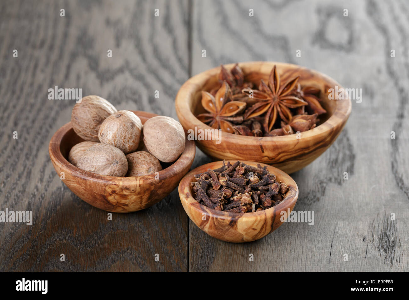 Les étoiles d'anis et de girofle Muscade dans bol d'olive sur la table en chêne, rustique Banque D'Images