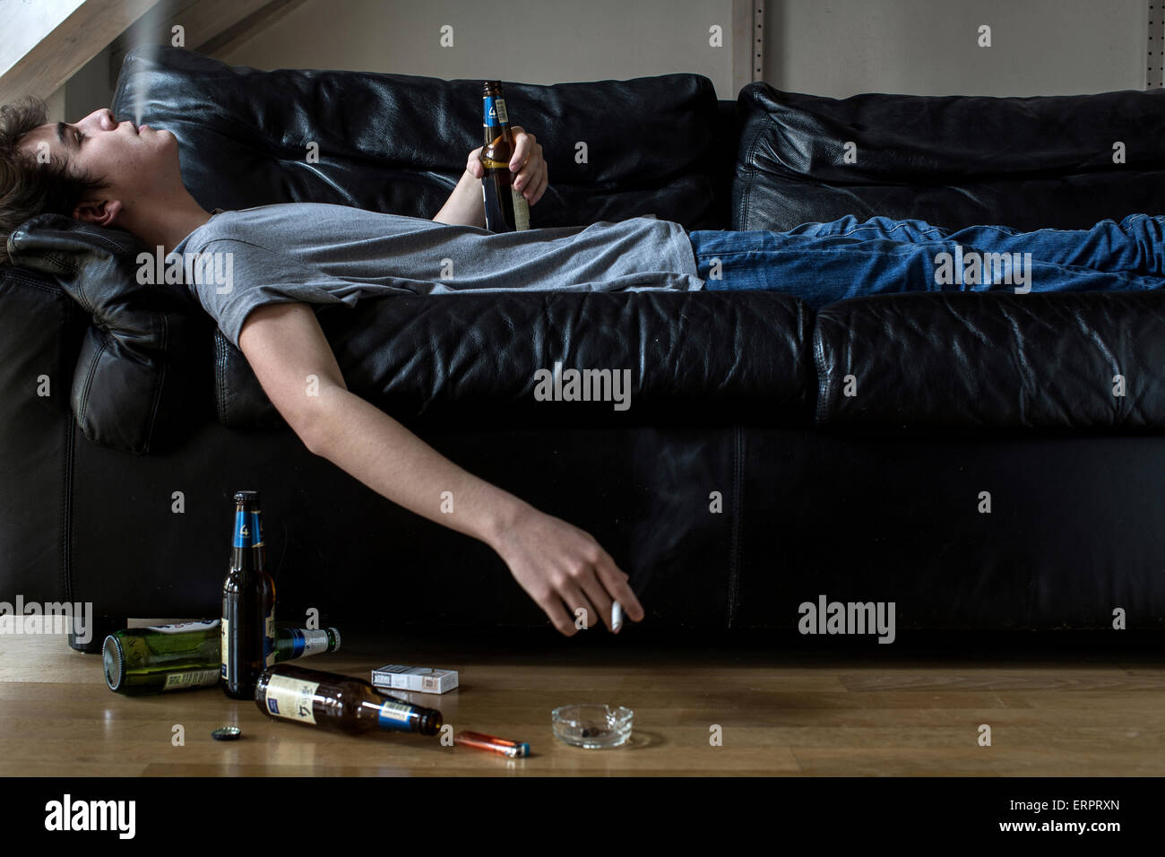 Parution du modèle. Young man holding bière et cigarette. Banque D'Images