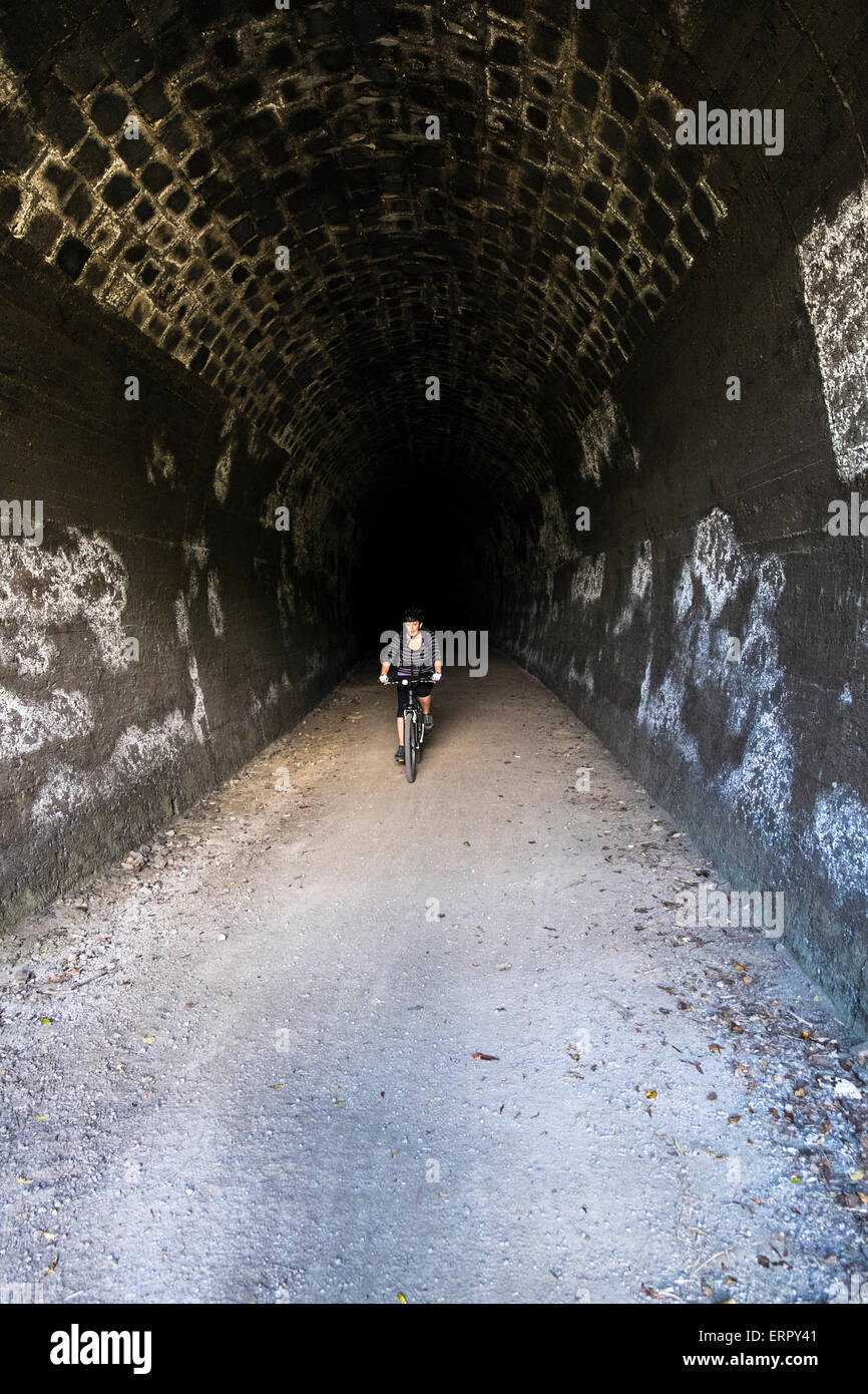 Cycliste qui sortent d'un tunnel ferroviaire abandonné sur l'ancienne île du nord tronc principal ligne à Ohakune, Nouvelle-Zélande Banque D'Images