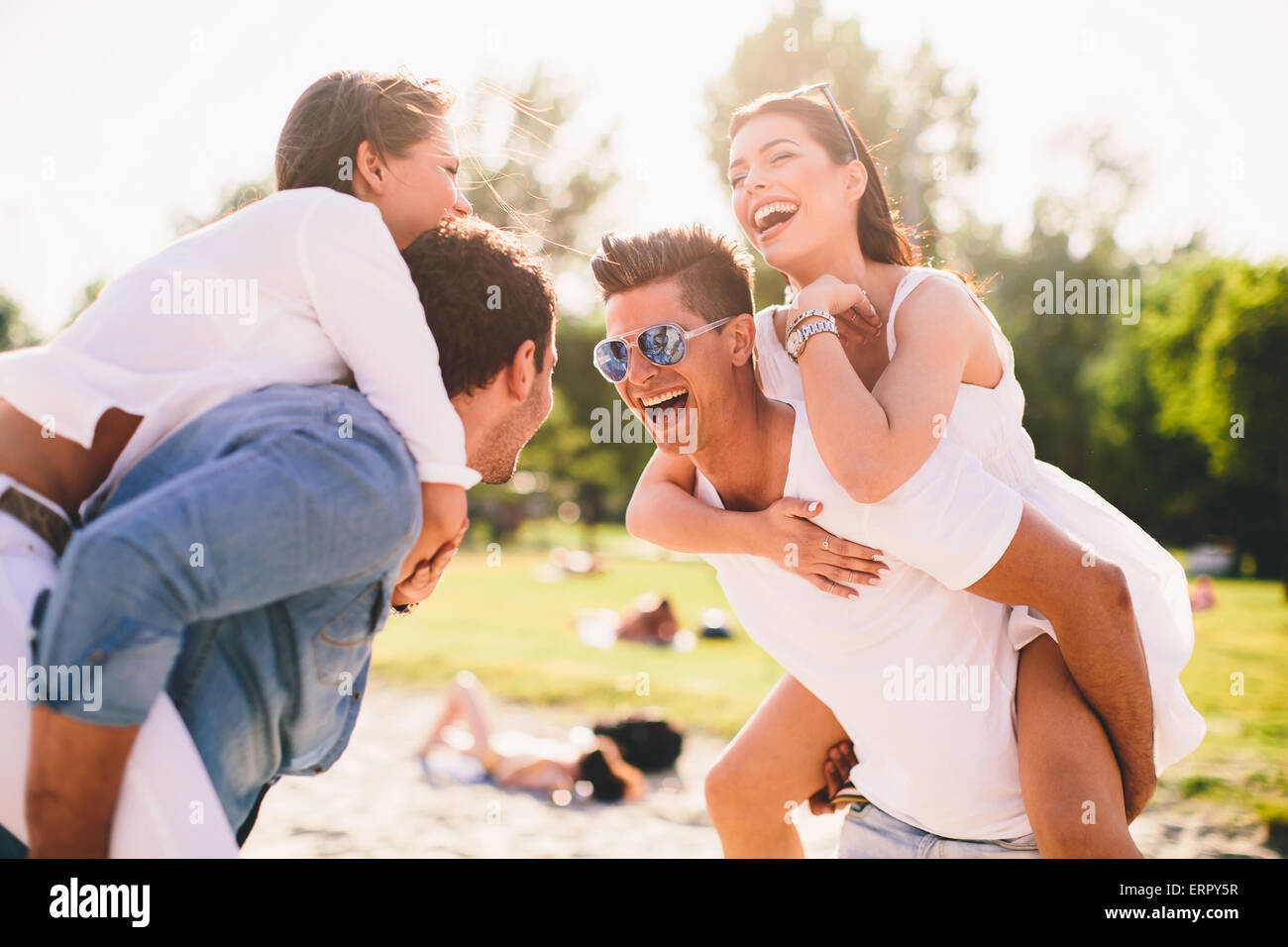 Les jeunes couples s'amusant sur la plage Banque D'Images