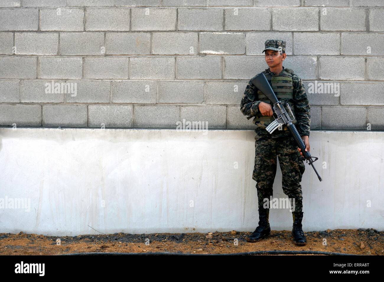 Un soldat de l'armée hondurienne monte la garde à l'extérieur de l'école primaire de Gabriela Mistral, 5 juin 2015 à Ocotes Alto Trujillo, village, au Honduras. Banque D'Images