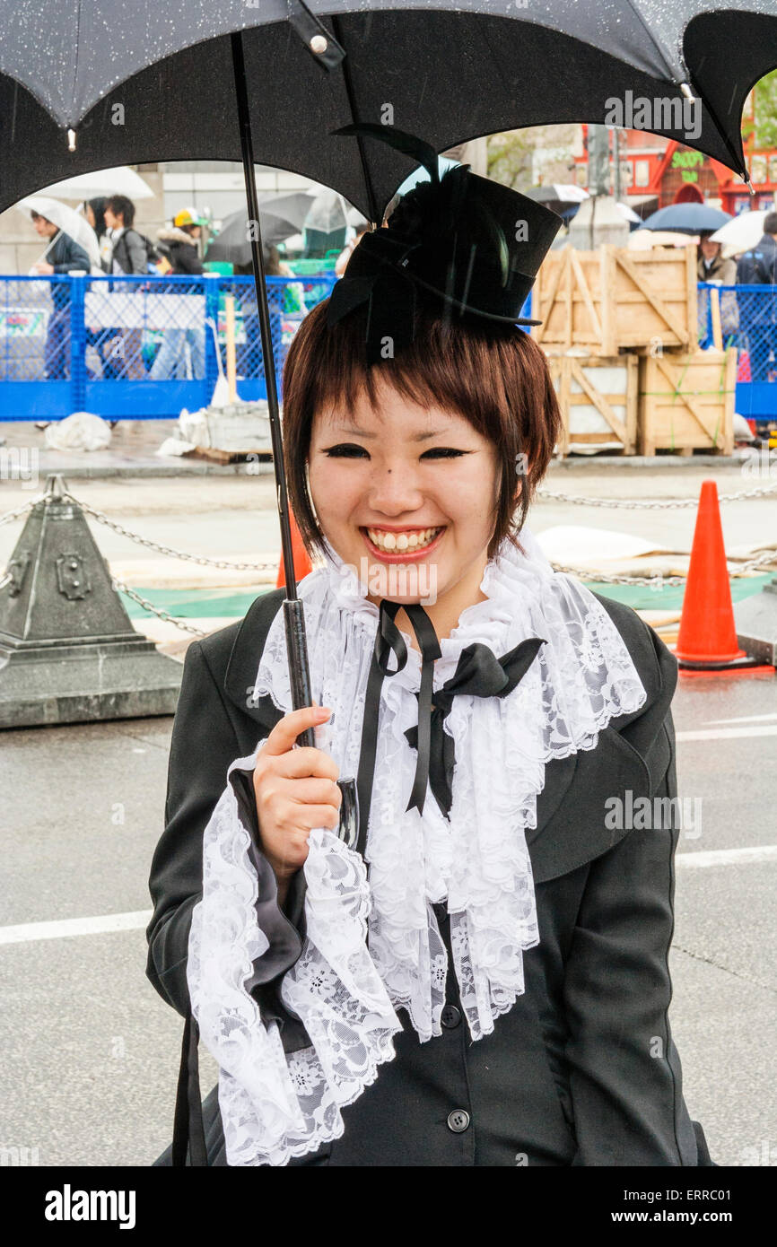Harajuku, Toyko. Jeune femme japonaise vêtue de la tenue de femme de  chambre victorienne de style 'Sweet Lolita' classique de style Lolita et  tenant un parapluie noir, souriant Photo Stock - Alamy