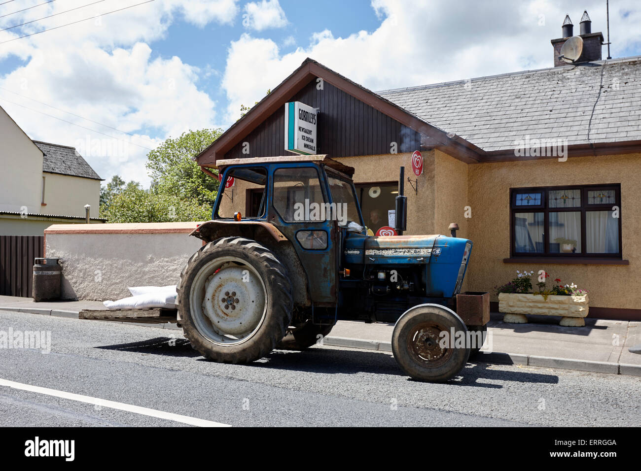 Vieux tracteur stationné à l'extérieur d'un magasin local dans un petit village de l'Irlande rurale emyvale monaghan Banque D'Images