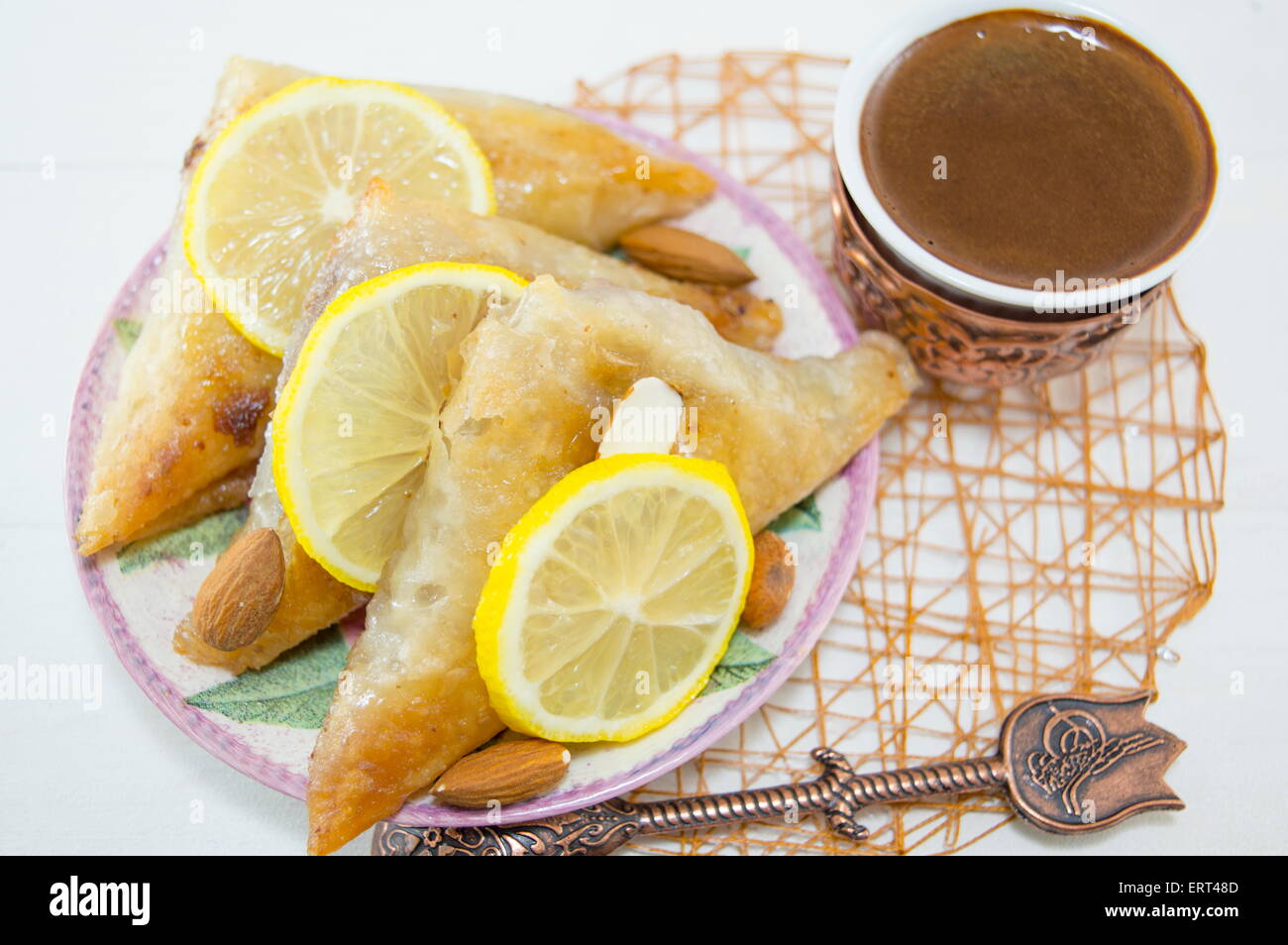 Baklava turc et le café dans une assiette avec des tranches de citrons Banque D'Images