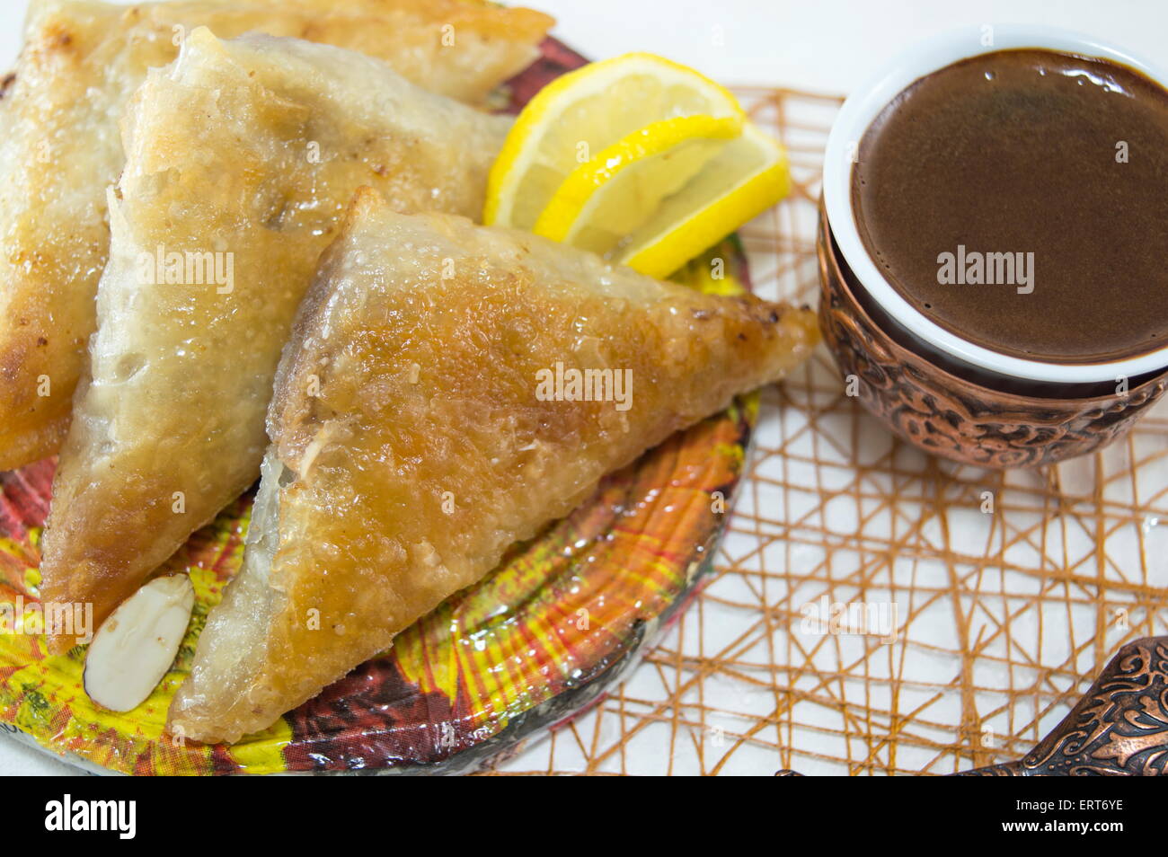 Baklava turc et le café dans une assiette avec des tranches de citrons Banque D'Images