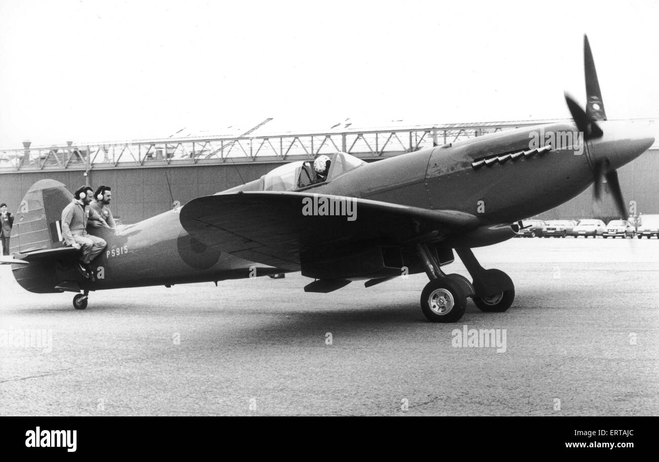 Un chasseur Spitfire de la RAF après avoir été rénové par British Aerospace les apprentis et le personnel après qu'il s'était tenu pendant des années comme une barrière de protection conducteur à RAF Bawdry au Pays de Galles. Le Spitfire PS915 a été remis à la RAF en condition opérationnelle de vol complet après trois années de travail sur la machine. Sur la photo, deux des ajusteurs de ridingm sur l'empennage de l'avion sur son chemin vers le haut trop de la piste pour décoller. L'avion est nise-lourd et besoin de 'lest' pour conserver la coupe vers le bas comme il taxis. mars 1987. Banque D'Images