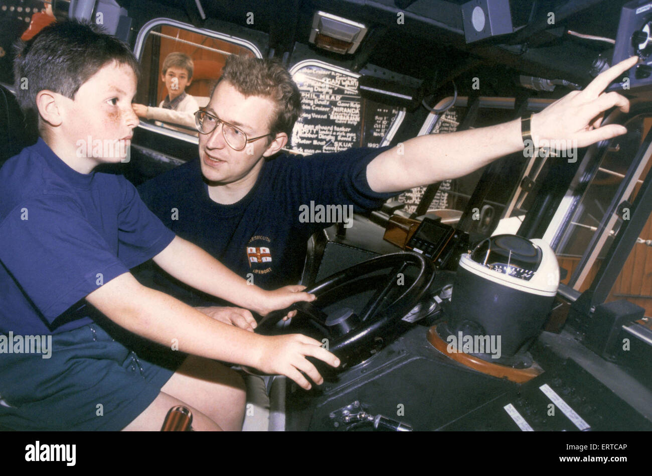 À l'intérieur de l'embarcation, port d'équipage Andrew Milne Adam donne la chance de s'asseoir Barmby dans le siège du conducteur. Station de Sauvetage de Teesmouth journée portes ouvertes annuelle, Redcar. 4e juillet 1993. Banque D'Images