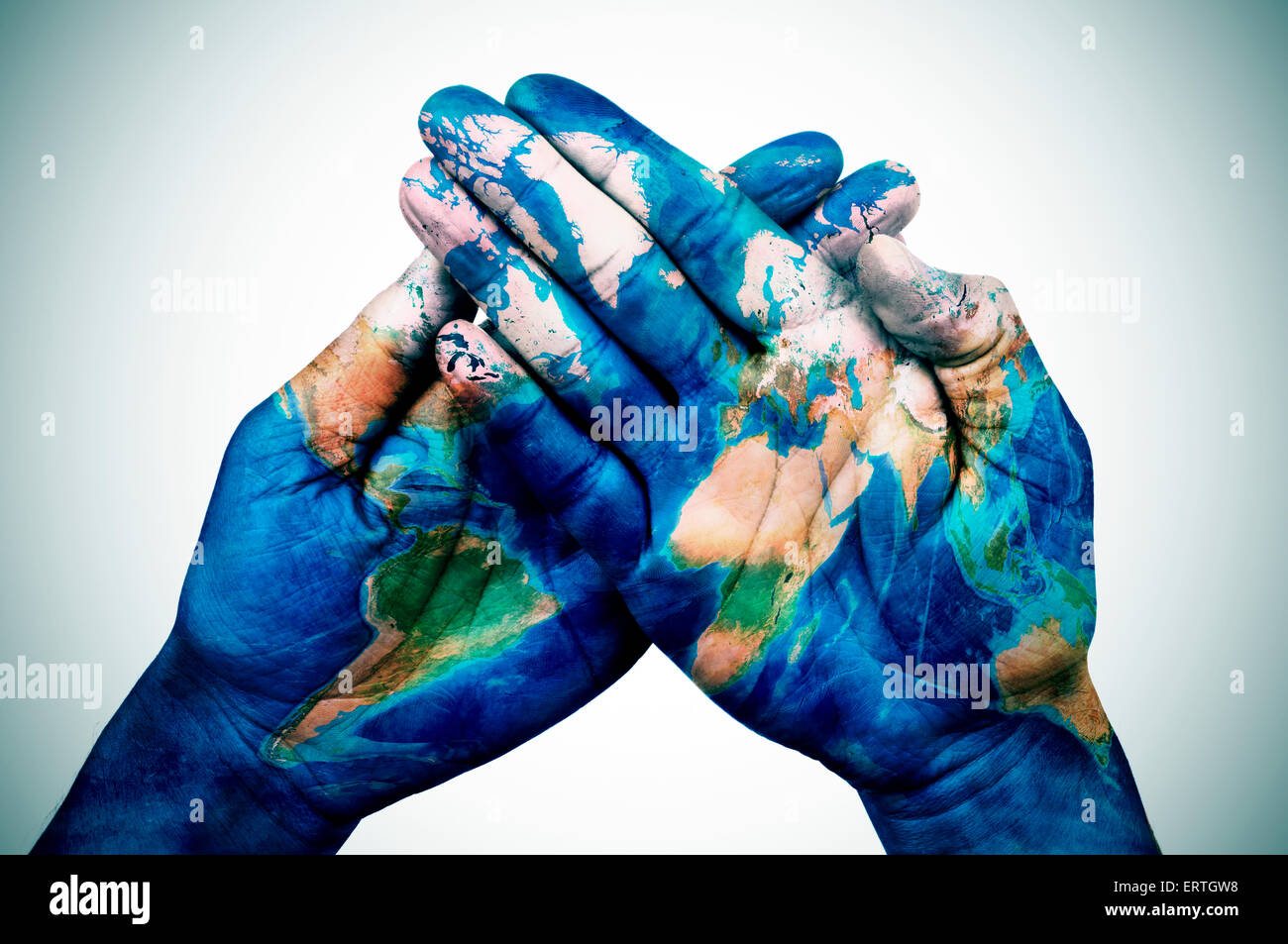 Les mains d'un jeune homme mis ensemble, avec une carte du monde (fourni par la NASA), légère ajouté vignette Banque D'Images