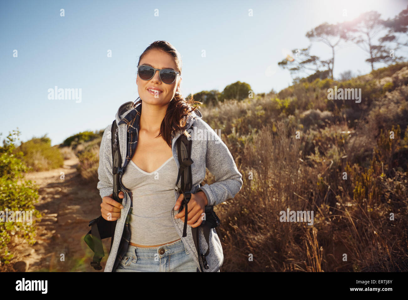 Portrait d'une belle jeune femme randonneur trekking dans la nature. Young caucasian woman wearing sunglasses looking at camera avec un Banque D'Images