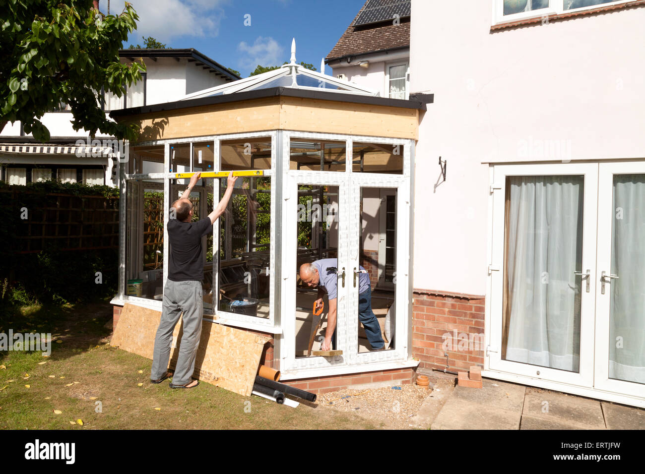 Les constructeurs à la construction d'une véranda dans le cadre d'une extension de maison, UK Banque D'Images