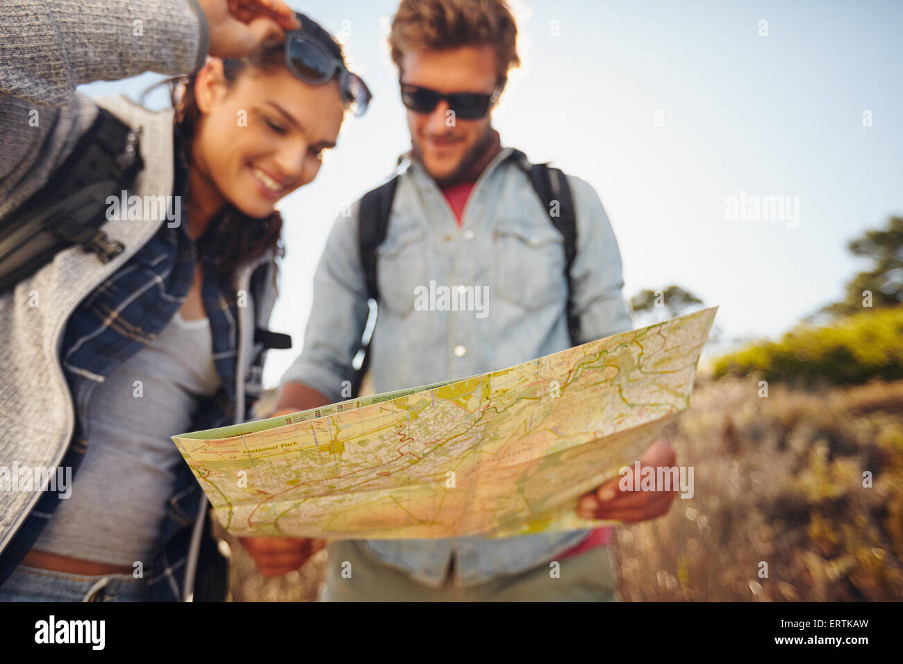 Jeune couple reading map on country walk. Caucasian hiker couple on randonnée pédestre à la directions sur la carte en main. Se concentrer sur la carte. Banque D'Images