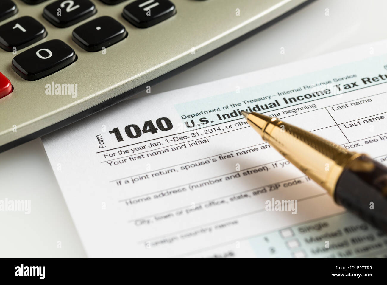 USA Formulaire d'impôt 1040 pour l'année 2014 avec un stylo et une calculatrice illustrant la réalisation de formulaires fiscaux pour l'IRS Banque D'Images
