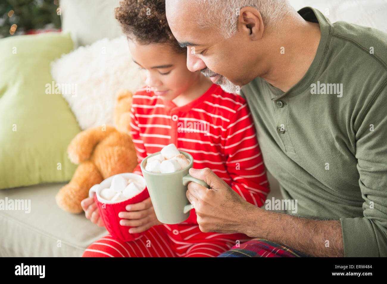 Mixed Race grand-père et petit-fils de boire un chocolat chaud à Noël Banque D'Images