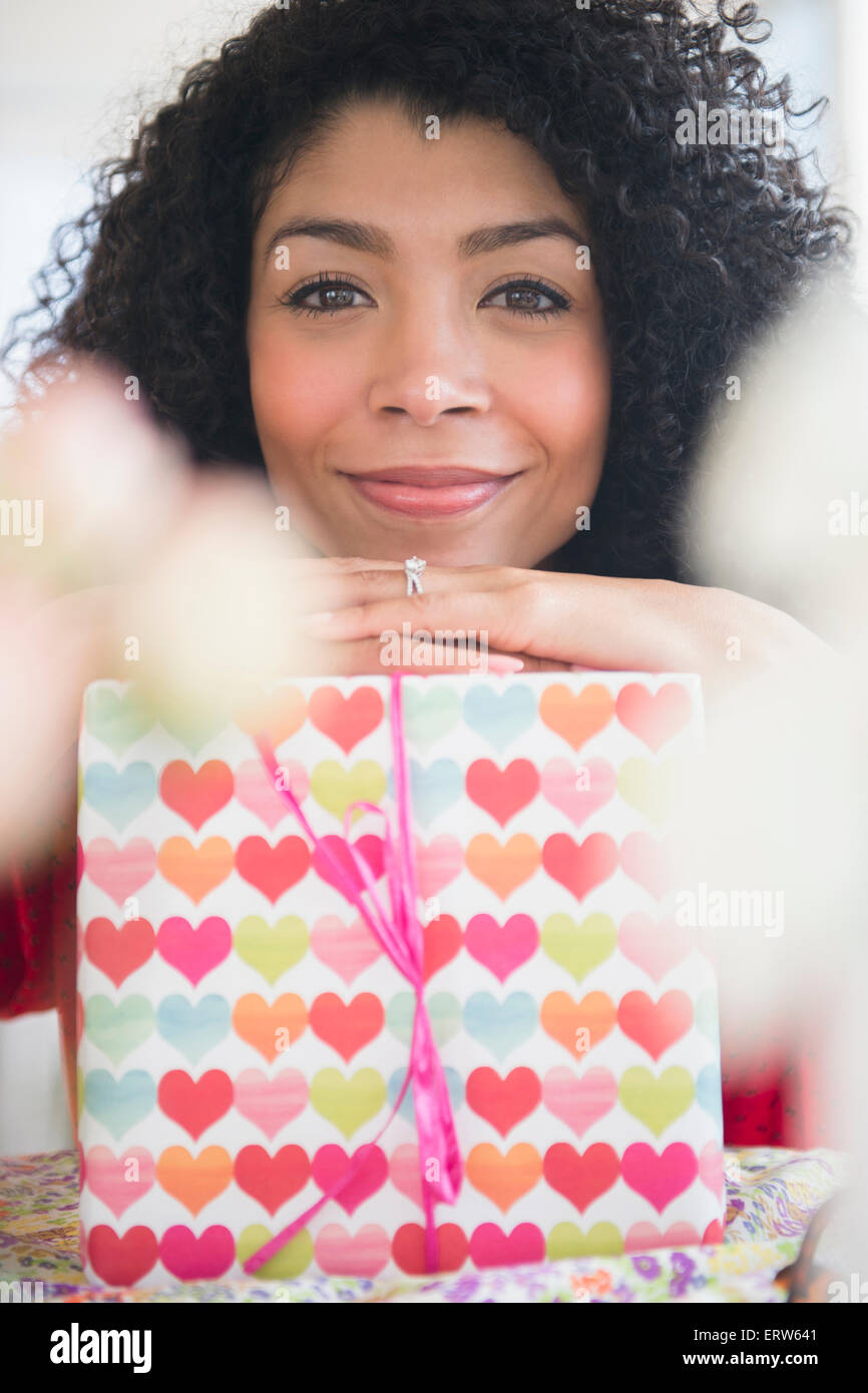 Mixed Race woman holding wrapped gift Banque D'Images