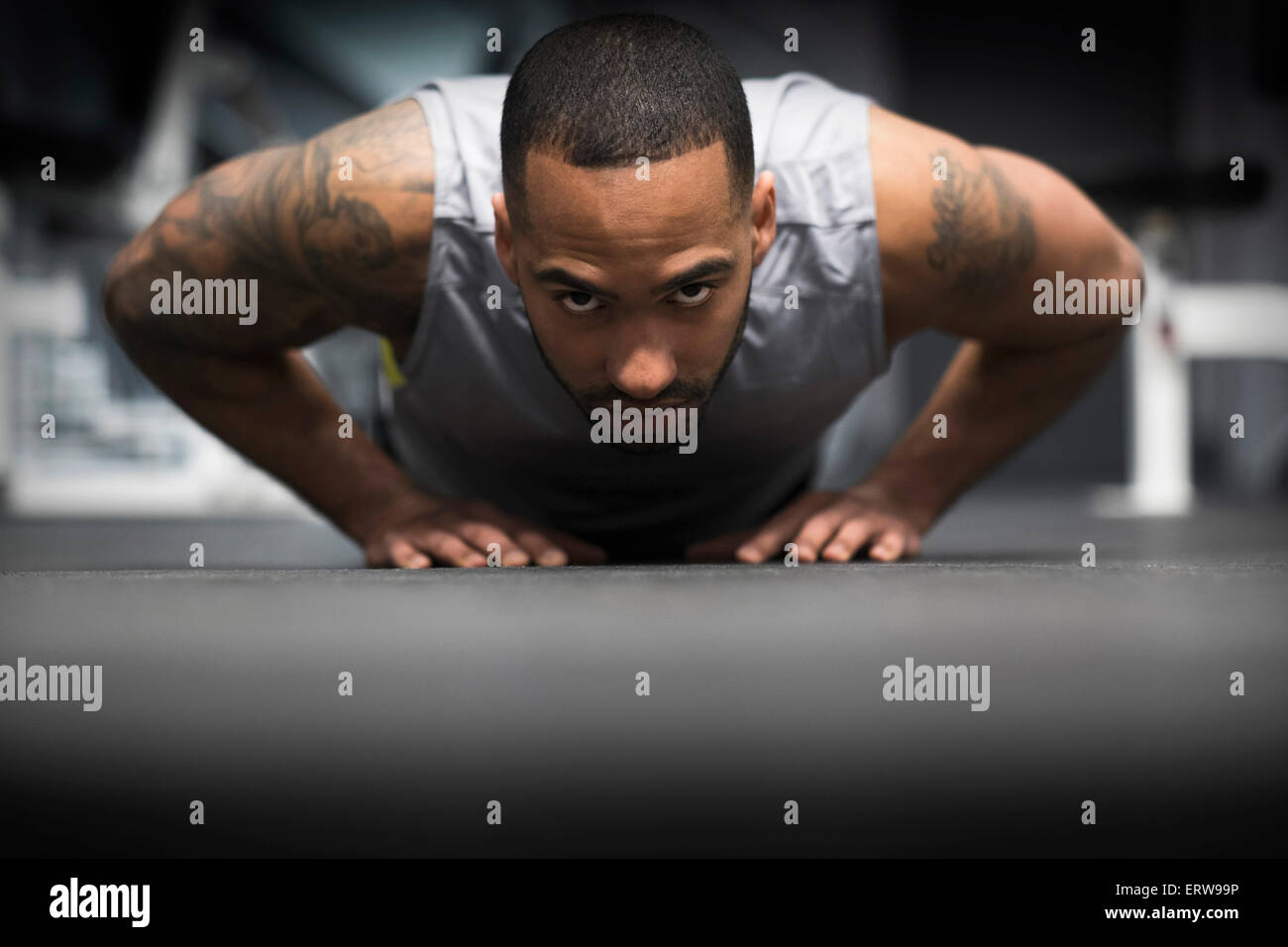 Hispanic man doing push-ups in gym Banque D'Images