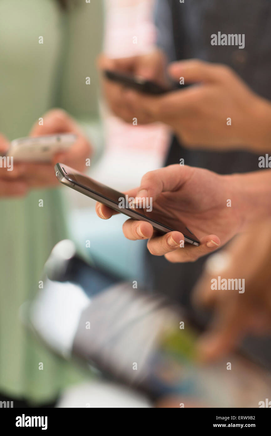 Près des mains de personnes des sms avec un téléphone cellulaire Banque D'Images