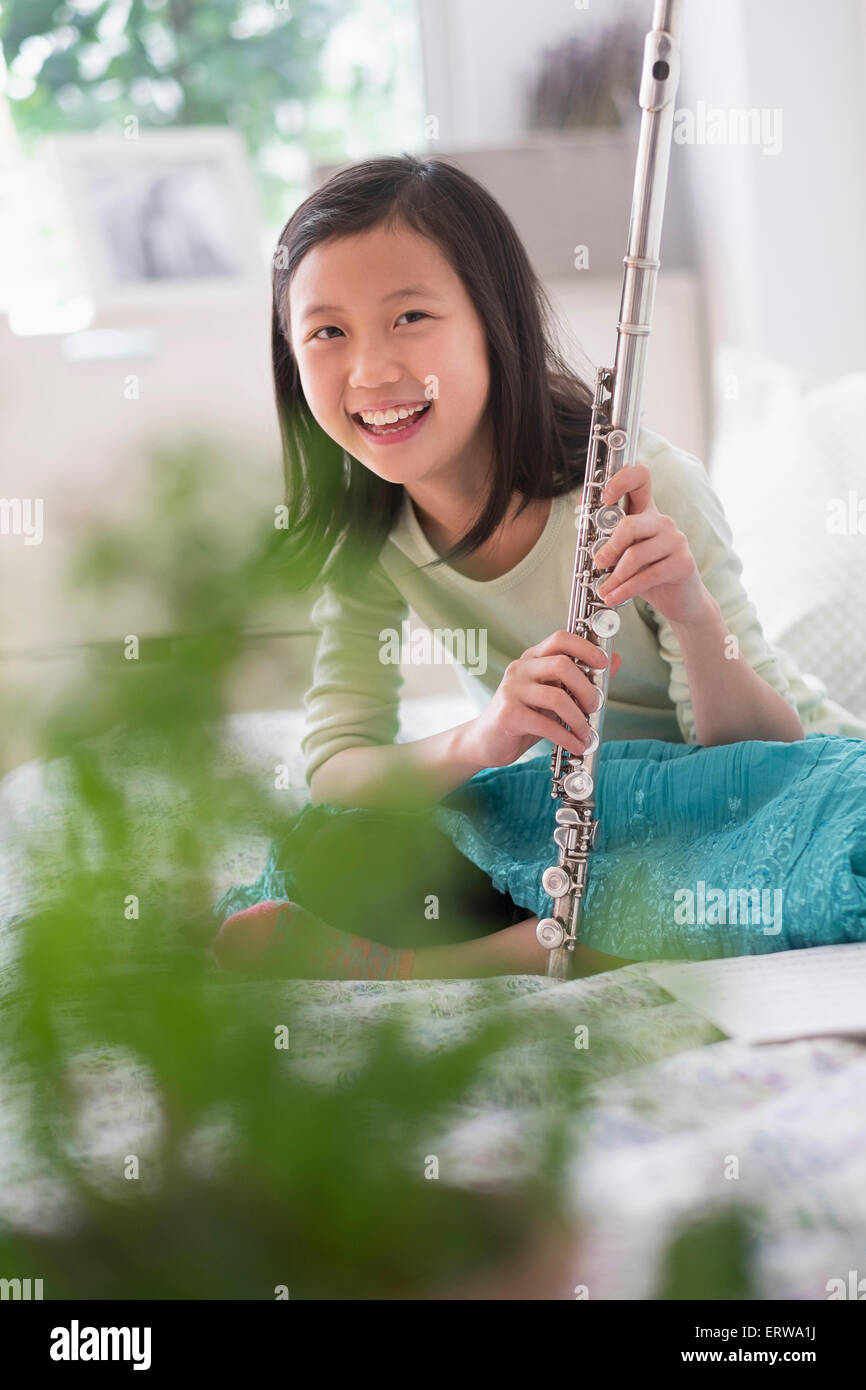 Chinese girl holding flute on bed Banque D'Images