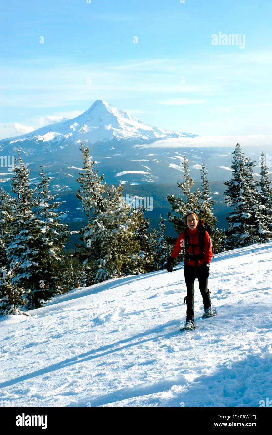 Une femme de 45 ans la randonnée Mont rebelle dans l'hiver avec Mt Hood dans l'arrière du terrain. Banque D'Images