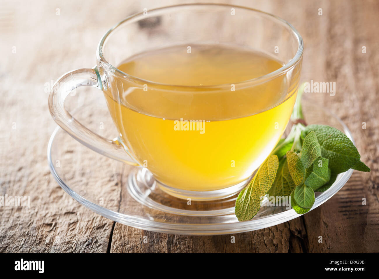 Sage de fines herbes avec du thé vert feuille dans verre tasse Banque D'Images