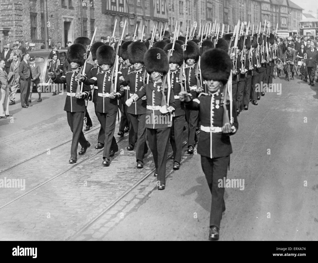 Ligne de foules les trottoirs comme pour regarder le mars de l'Coldstream Guards de Fenham caserne pour la Cathédrale de Newcastle. Juin 1938. Banque D'Images