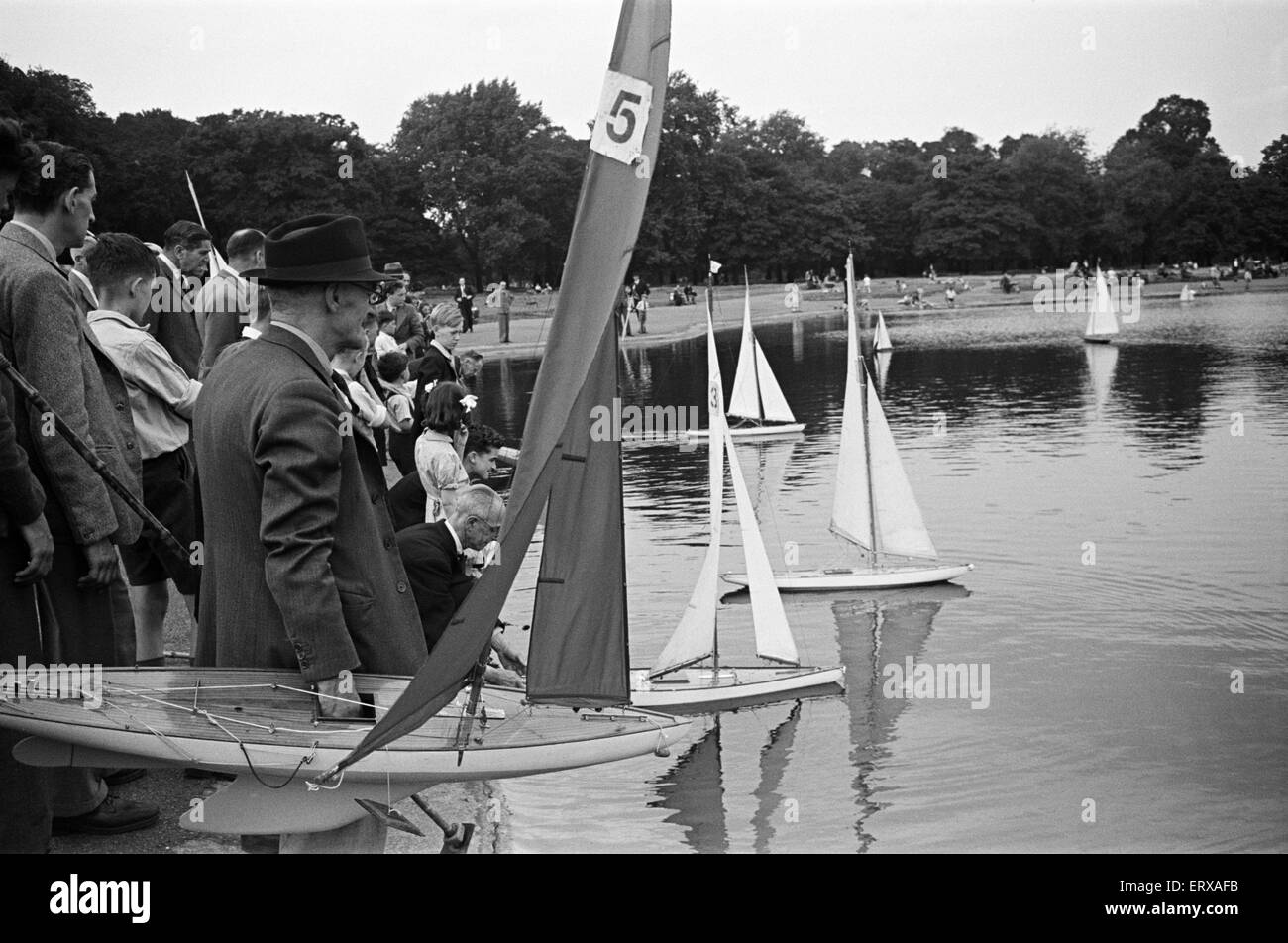 Les enfants et les adultes leur voile yachts jouet sur le bassin rond dans Kensington Gardens, Londres, 25 août 1947. Banque D'Images