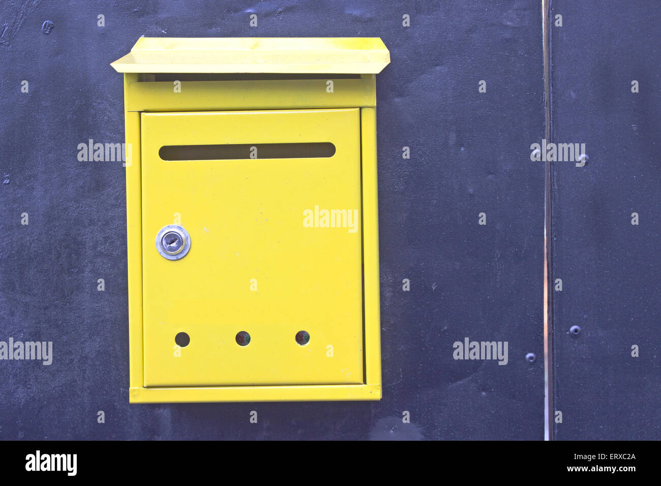 Les boîtes aux lettres jaunes sur fond bleu métal Banque D'Images