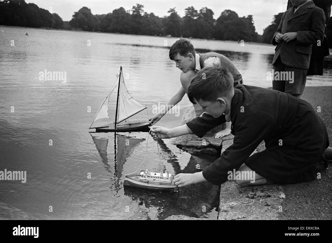 À leurs enfants sur les bateaux jouets bassin rond dans Kensington Gardens, Londres, 25 août 1947. Banque D'Images