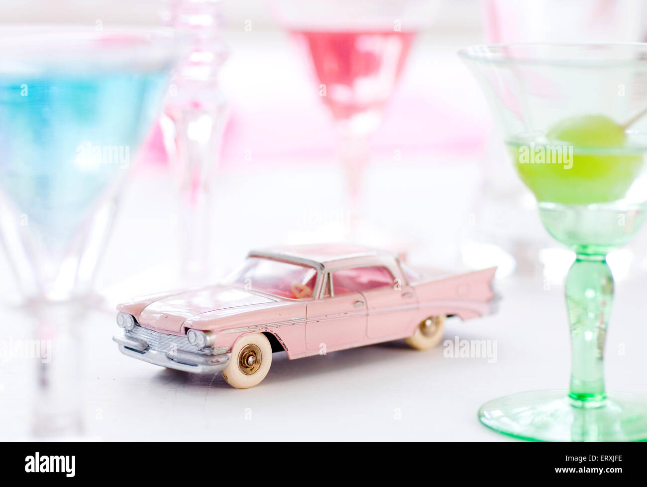 Jouet rose dinky Chrysler Saratoga voiture entourée de boissons exotiques sur une table Banque D'Images