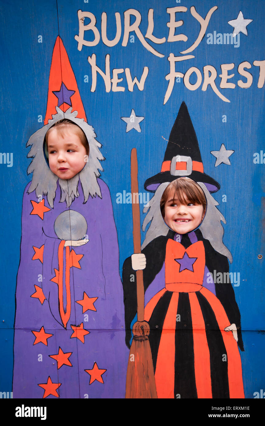 Deux enfants avec leurs têtes à travers un conseil avec les sorcières sur au Burley dans la New Forest Hampshire England UK Banque D'Images