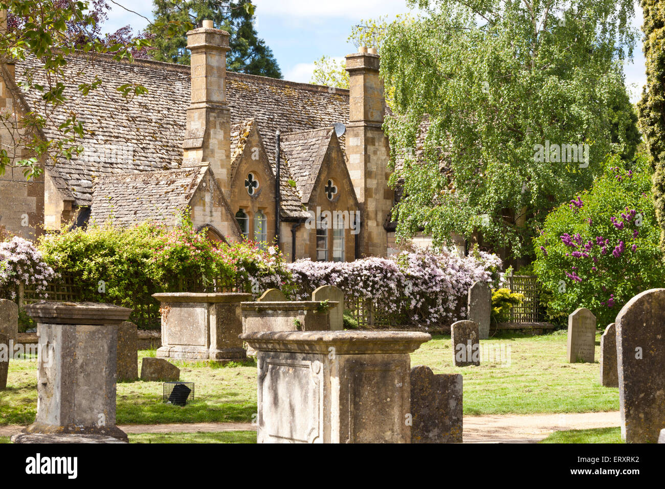 Le printemps dans les Cotswolds - la vieille école à côté du cimetière dans la ville de Cotswolds Gloucestershire Cheltenham, UK Banque D'Images