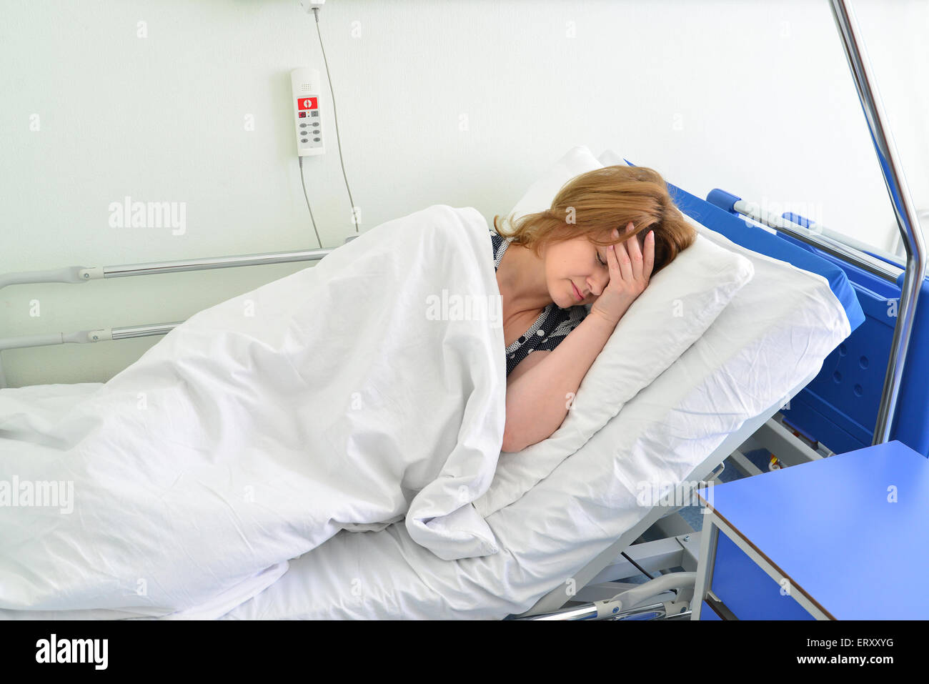 Female patient lying on a bed in hospital ward Banque D'Images