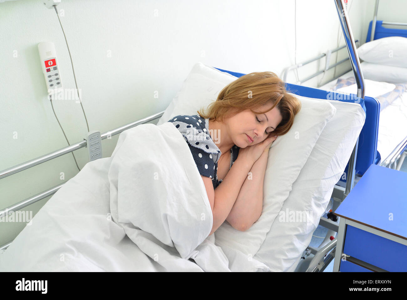 Female patient lying on a bed in hospital ward Banque D'Images