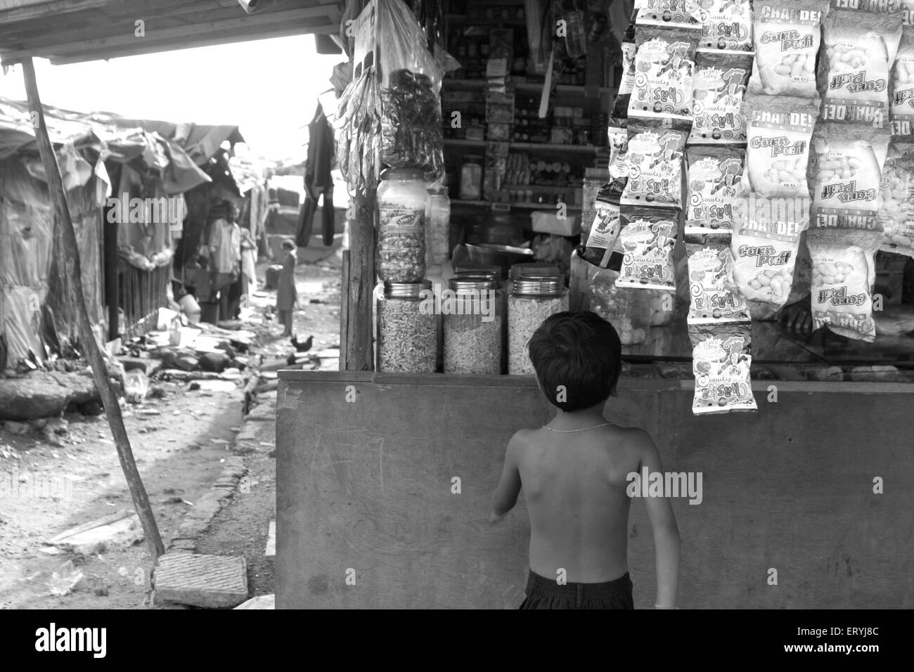 Enfant devant le bidonville malvani magasin ; Malad ; Bombay , Mumbai ; Maharashtra ; Inde , asie bidonvilles indiens Banque D'Images