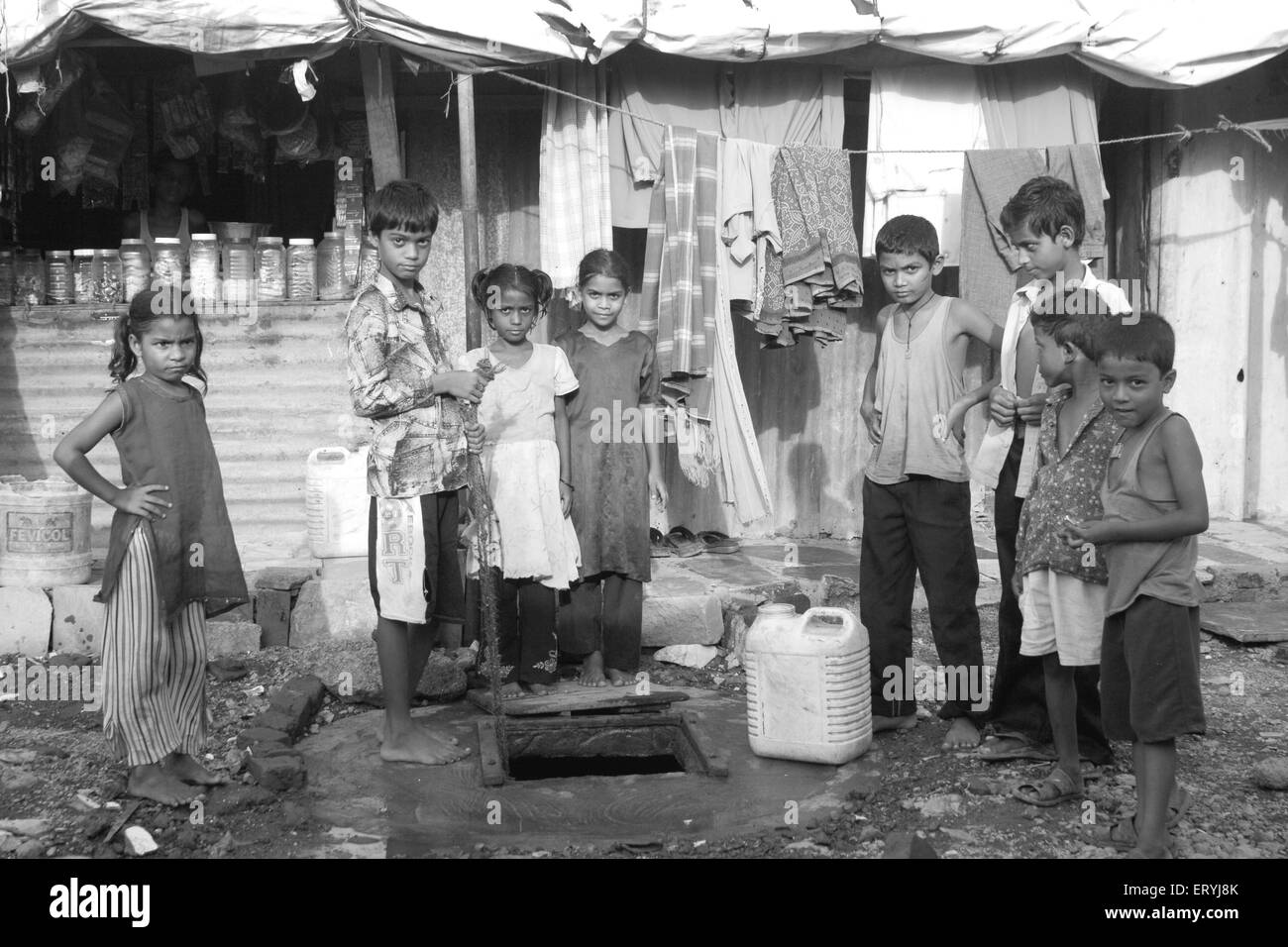Les enfants dans des bidonvilles à la collecte de l'eau dans le bidonville de Malad Malvani Bombay Mumbai Maharashtra Inde Banque D'Images
