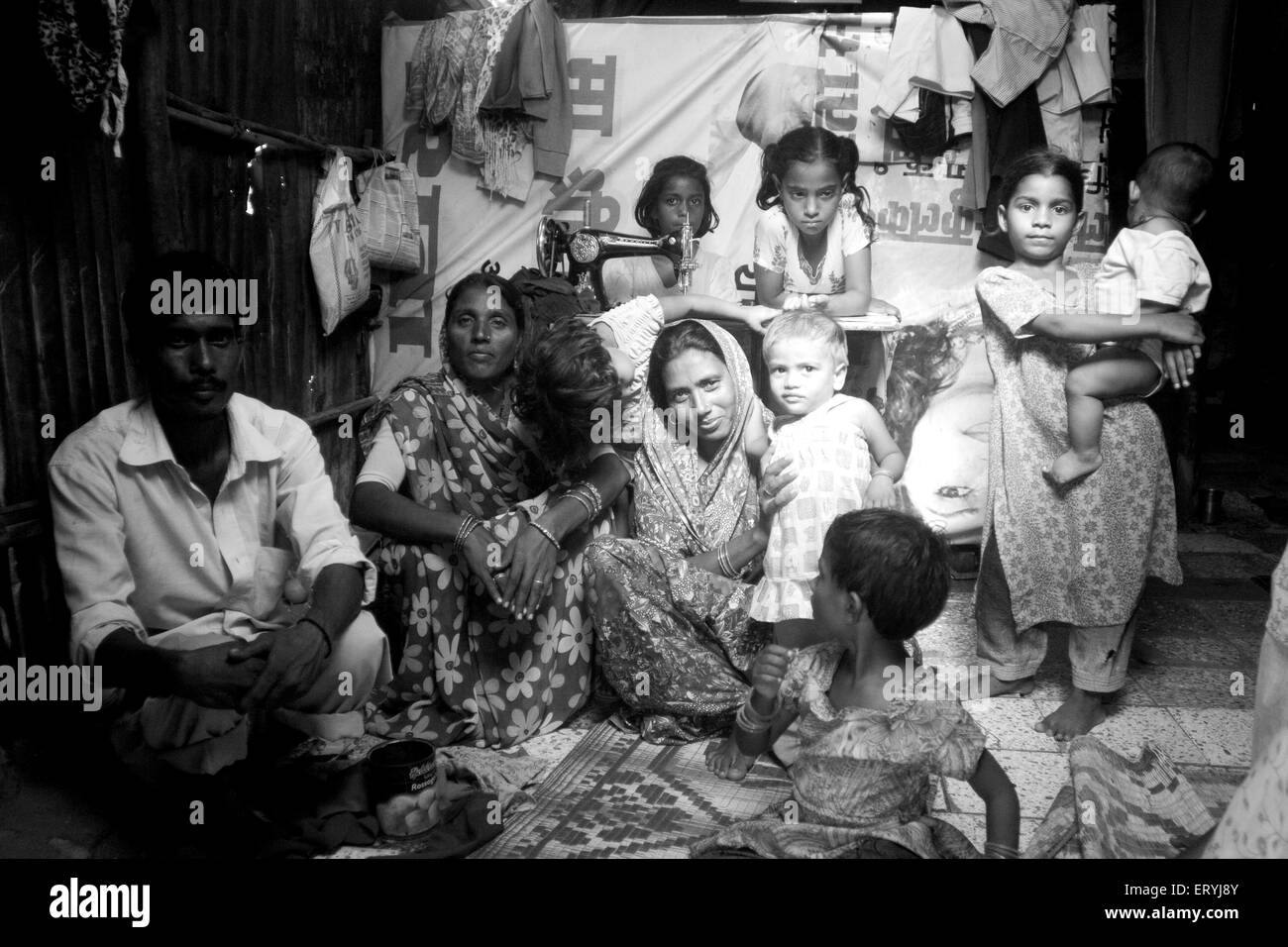Famille avec machine à coudre dans Malvani Malad de taudis ; ; ; Bombay Mumbai Maharashtra Inde ; PAS DE MR Banque D'Images