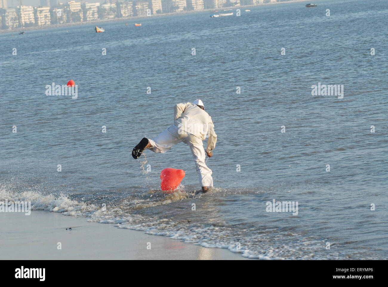 Hawker attrapant son ballon rouge à girgaum chowpatty beach Bombay Mumbai ; ; ; ; Maharashtra Inde Banque D'Images